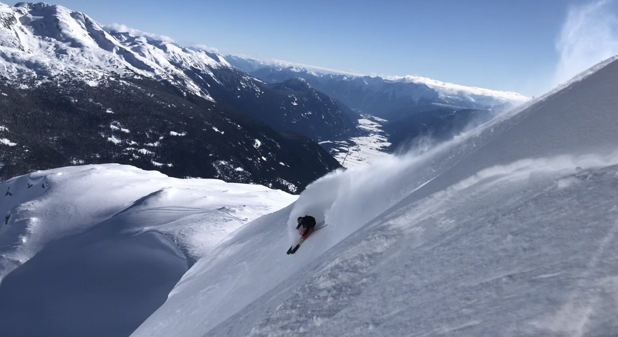 Thomas skiing through deep snow on a mountain slope